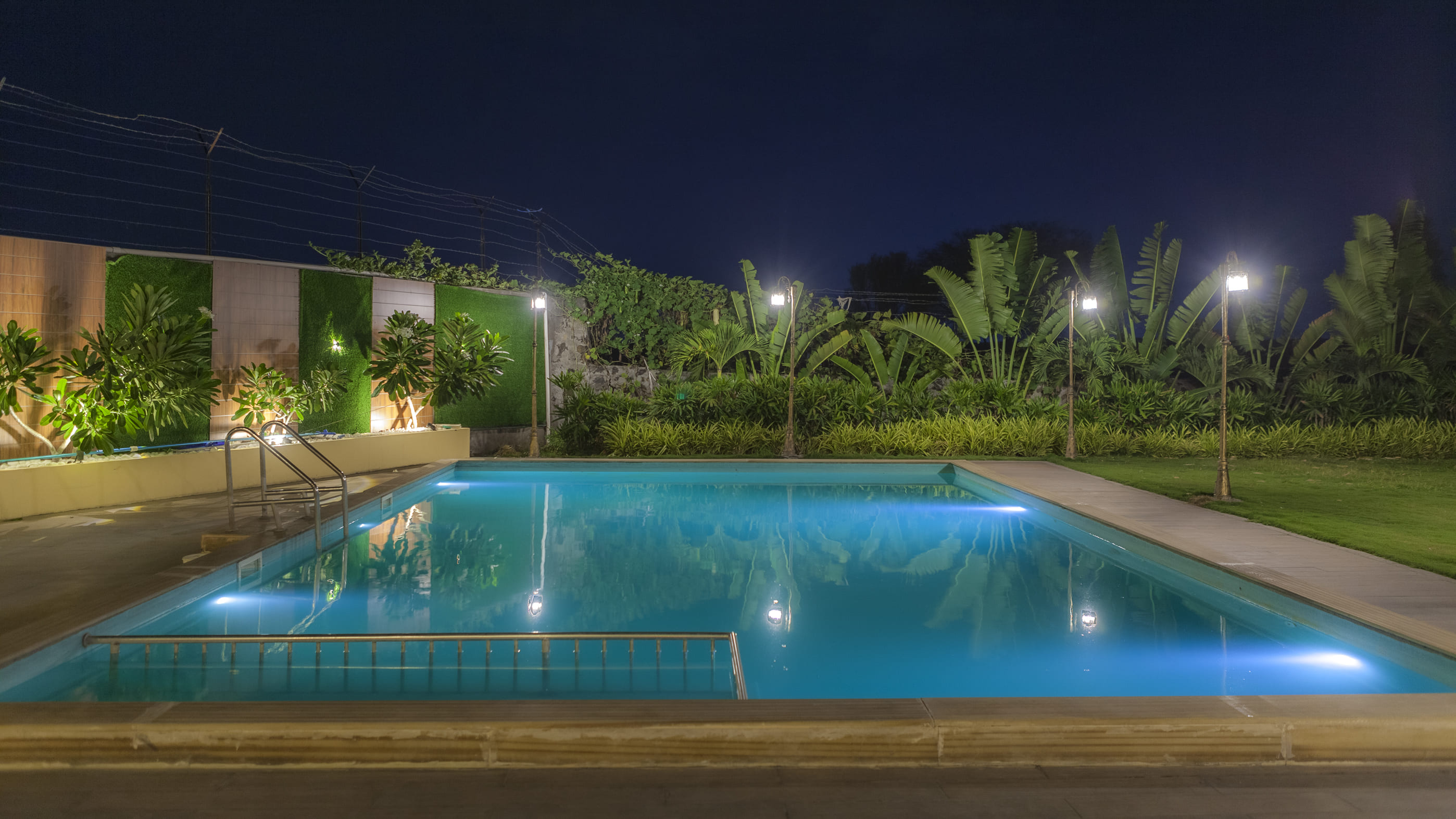 Arowana Villa swimming pool at night with lush gardens, peaceful surroundings, and spacious outdoor seating, ideal for family vacations, private stays, group stays, and luxury villa experiences.